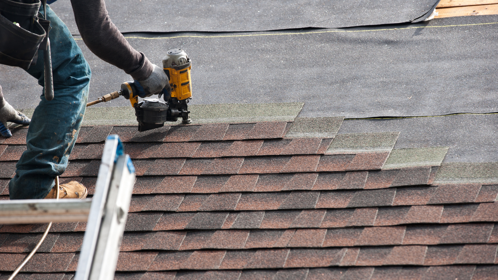 Professional roofer installing shingles with a nail gun, representing high-quality roofing work promoted through Google Ads for Roofers.